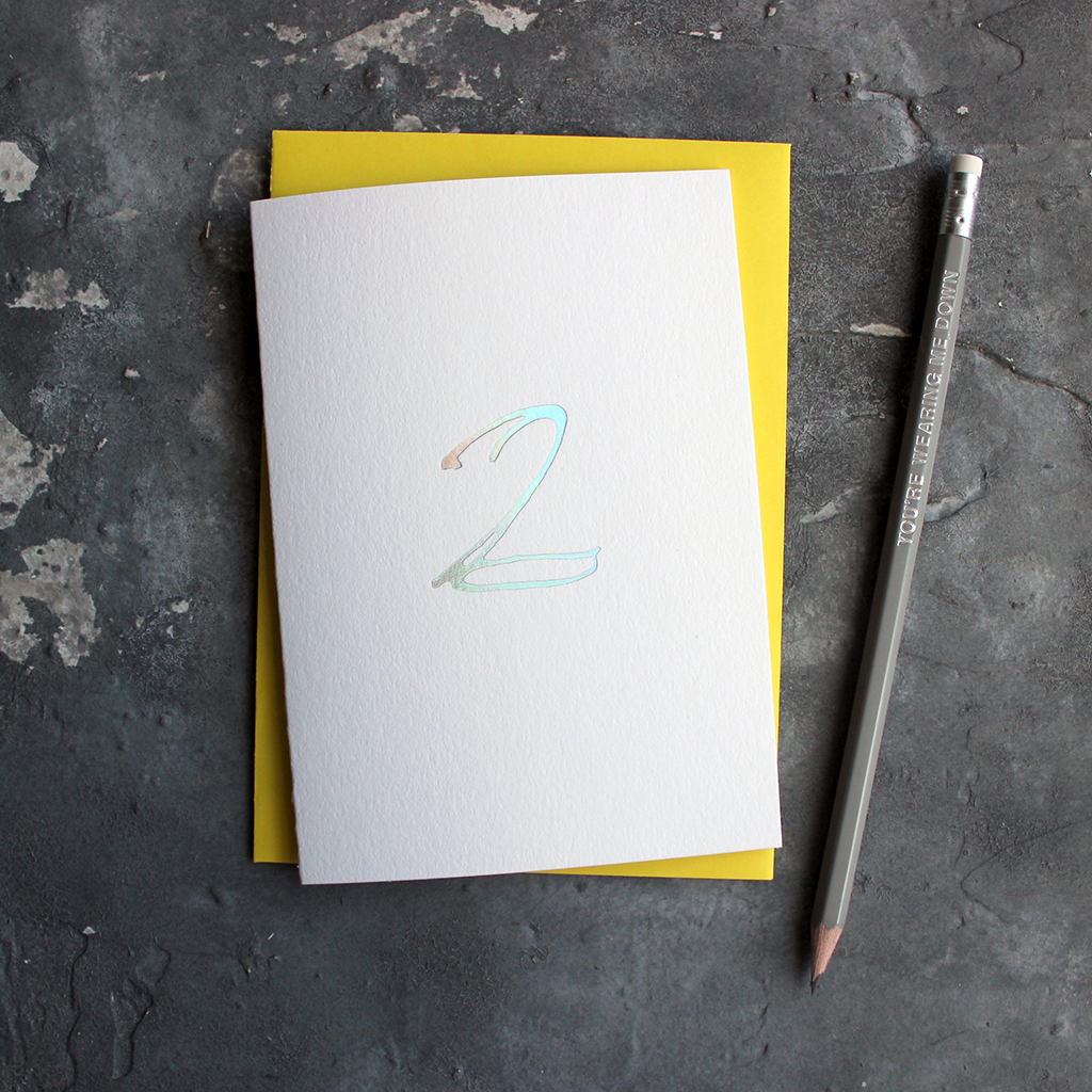 A second birthday card with a hand drawn number two hand pressed in holographic foil on the front