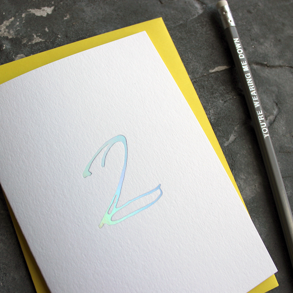 A second birthday card with a hand drawn number two hand pressed in holographic foil on the front