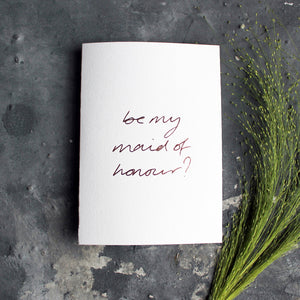 this hand foiled card asks 'be my maid of honour?' on the front in handwriting on white paper