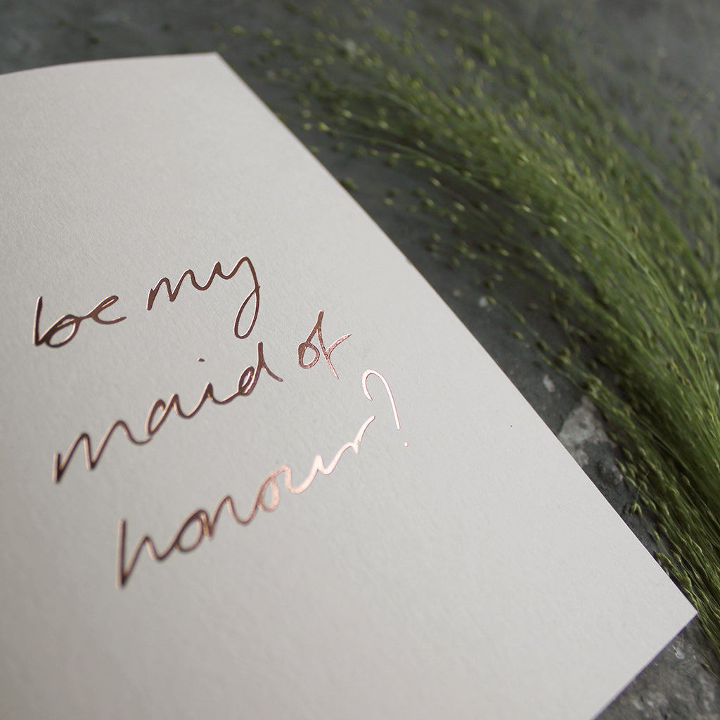 this hand foiled card asks 'be my maid of honour?' on the front in handwriting on blush coloured paper