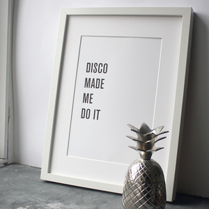 The words 'Disco Made Me Do It' is a black and white typographic design in a frame