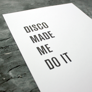 The words 'Disco Made Me Do It' is a black and white typographic design in a frame