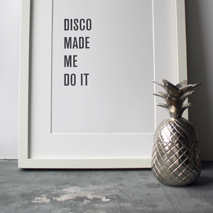 The words 'Disco Made Me Do It' is a black and white typographic design in a frame