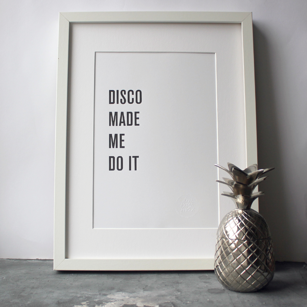 The words 'Disco Made Me Do It' is a black and white typographic design in a frame
