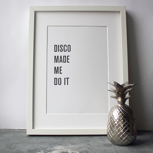 The words 'Disco Made Me Do It' is a black and white typographic design in a frame