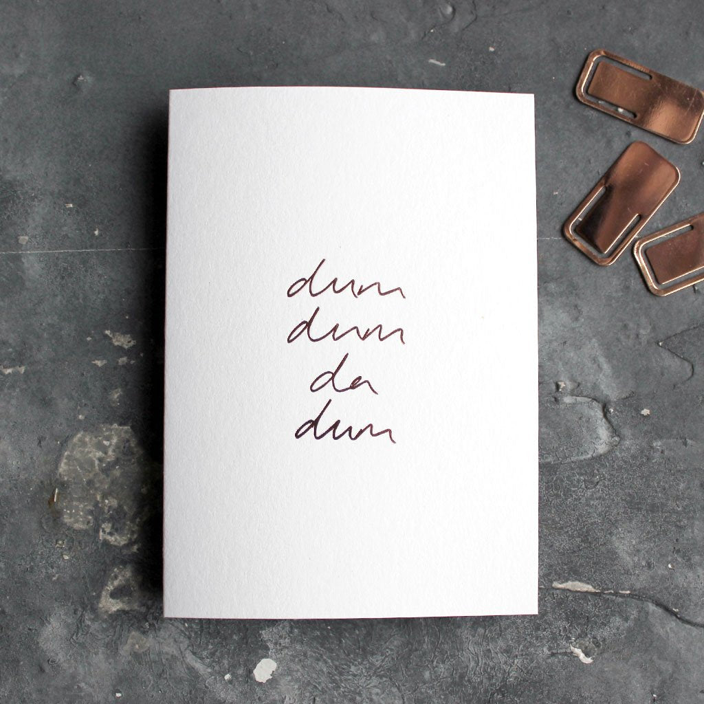 This rose gold hand foiled luxury white card says Dum Dum Da Dum on the front in handwriting from Text From A Friend