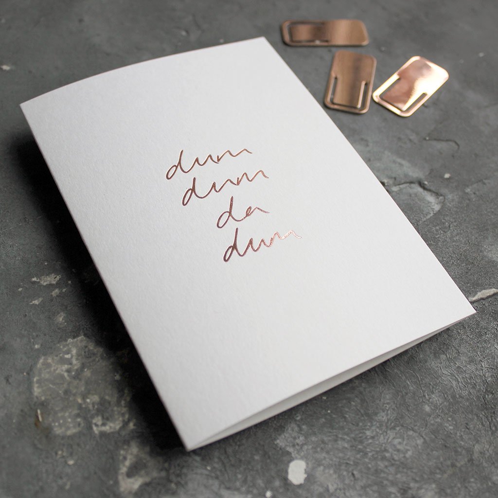This rose gold hand foiled luxury white card says Dum Dum Da Dum on the front in handwriting from Text From A Friend