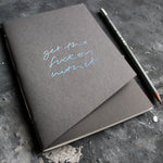 a grey handmade luxury notebook that's hand foiled with the message Get The Fuck On With It in holographic foil