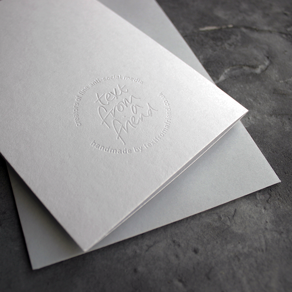 the back of the card has a hand foiled transparent logo that says Text From a Friend