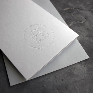 the back of the card has a hand foiled transparent logo that says Text From a Friend