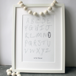 This children's personalised alphabet print is a unique hand drawn typography design in grey and black letters on white paper.