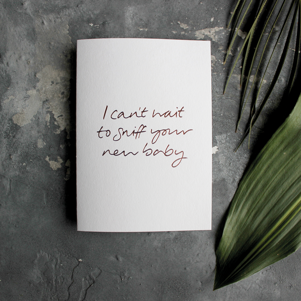 The front of the card has the phrase 'I can't wait to sniff your new baby' handwritten and hand pressed in rose gold foil