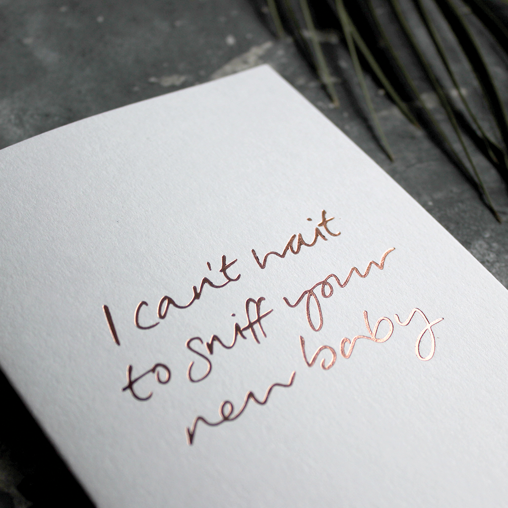The front of the card has the phrase 'I can't wait to sniff your new baby' handwritten and hand pressed in rose gold foil