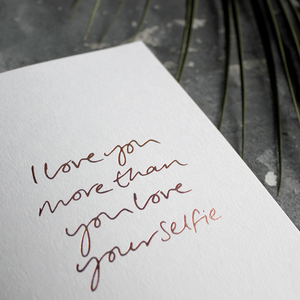 The front of the card says I love you more than you love your selfie and is stamped in rose gold foil