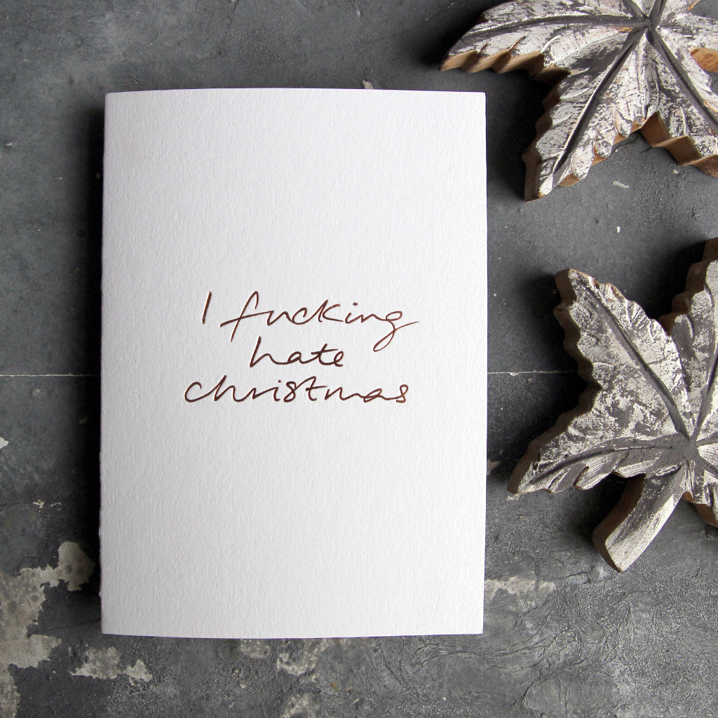 This christmas card says I Fucking Hate Christmas on hand foiled on white luxury paper on grey board