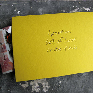 This cash card says I Put A Lot Of Love Into This and is handwritten and hand printed in pale lime foil on lime luxury paper on grey board