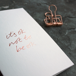 It's Ok Not To Be Ok is a luxury white coloured card and hand foiled in rose gold on the front