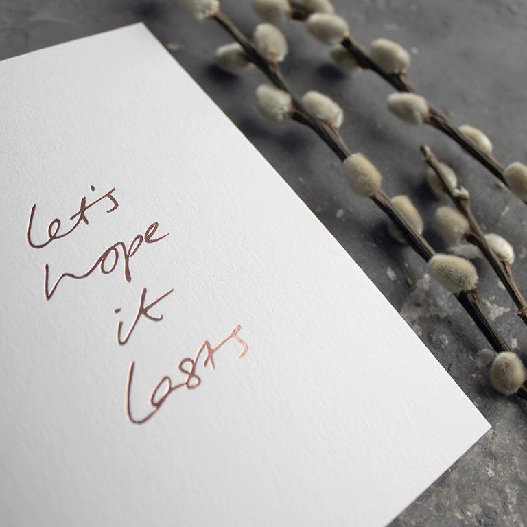 this hand foiled white luxury card say 'let's hope it lasts' on the front