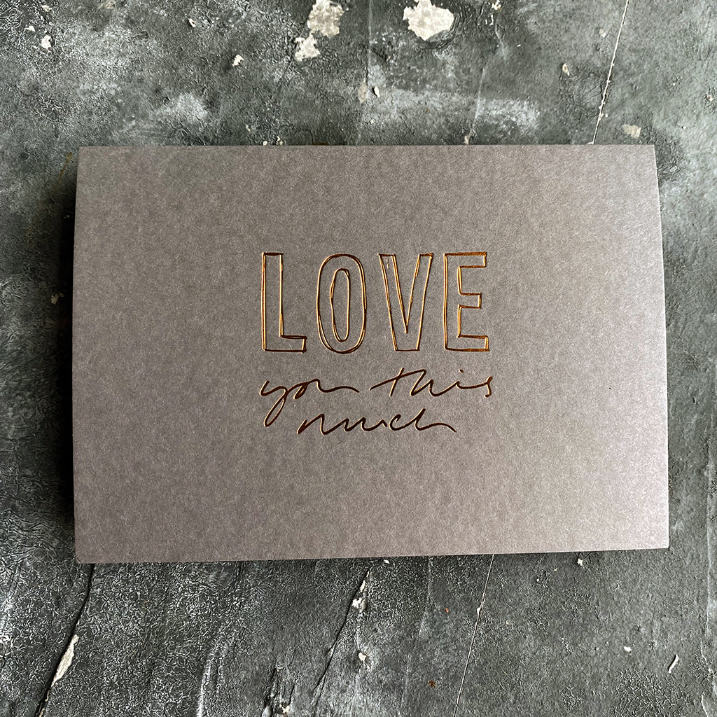 this hand foiled smoke grey coloured cash card says 'Love You This Much' on the front in bronze foil