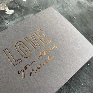 this hand foiled smoke grey coloured cash card says 'Love You This Much' on the front in bronze foil