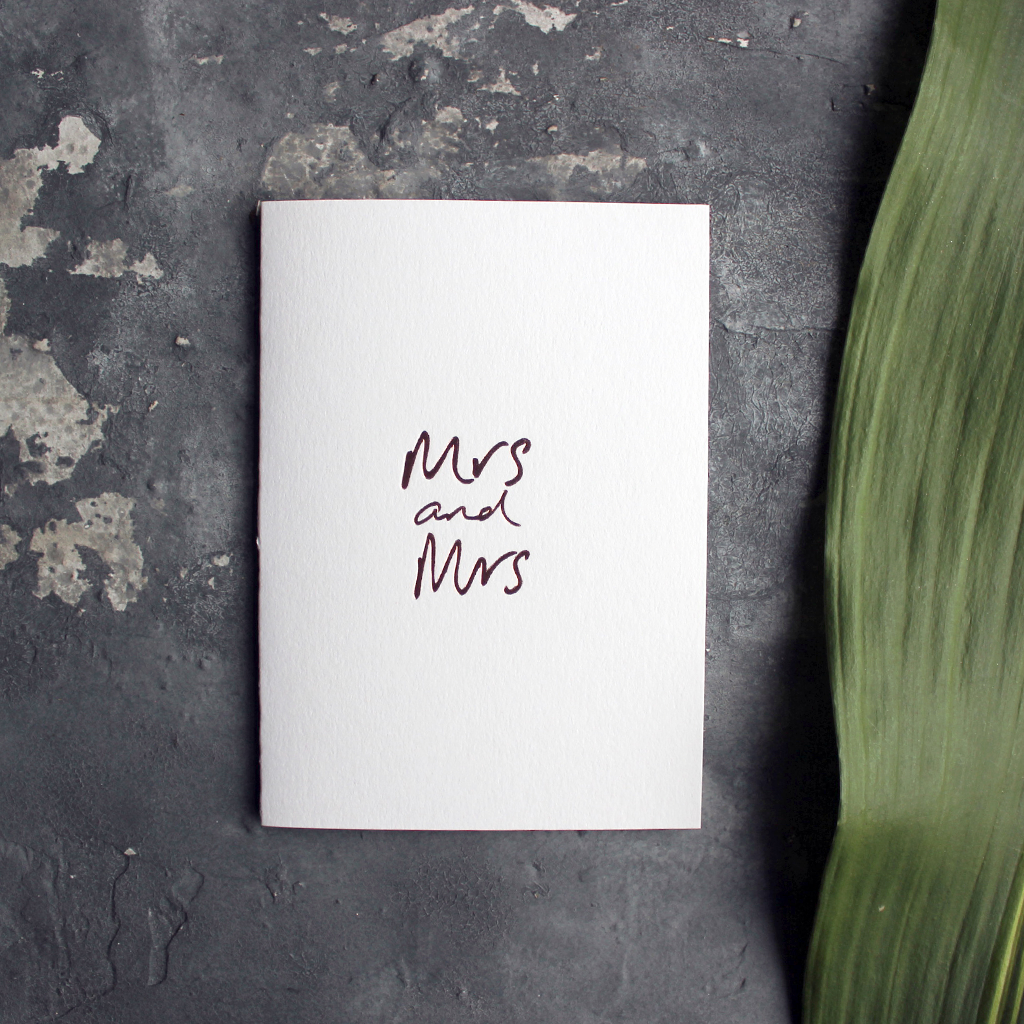 this luxury wedding card for the gay couple says Mrs and Mrs on the front, handwritten and hand foiled in rose gold