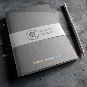 a grey handmade luxury notebook that's hand foiled with the message Never Not Procrastinating