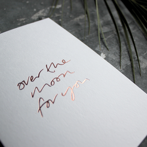 The front of this luxury card says Over The Moon For You and is handwritten and hand foiled in rose gold