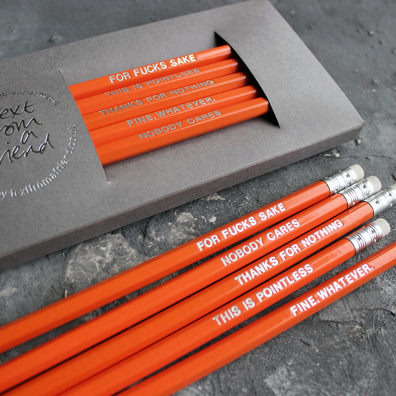 Orange HB pencils printed with silver foil phrases and packaged in a grey paper box. 