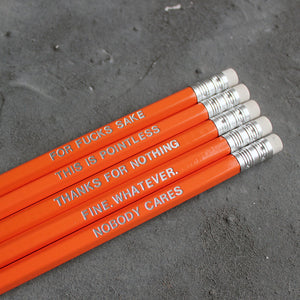 Orange HB pencils printed with silver foil phrases and packaged in a grey paper box. 