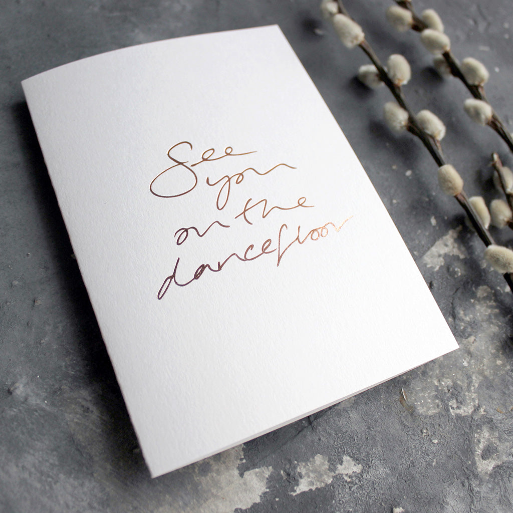 This luxury white hand foiled card says 'see you on the dancefloor' on the front