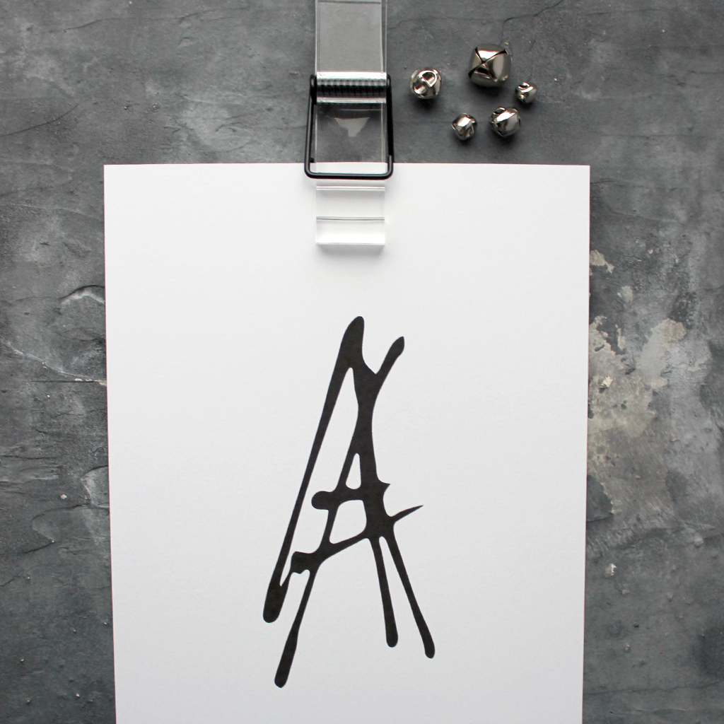 This initial print is a unique hand drawn typography design in black on white paper.