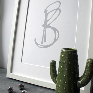This initial print is a unique hand drawn typography design in grey on white paper.
