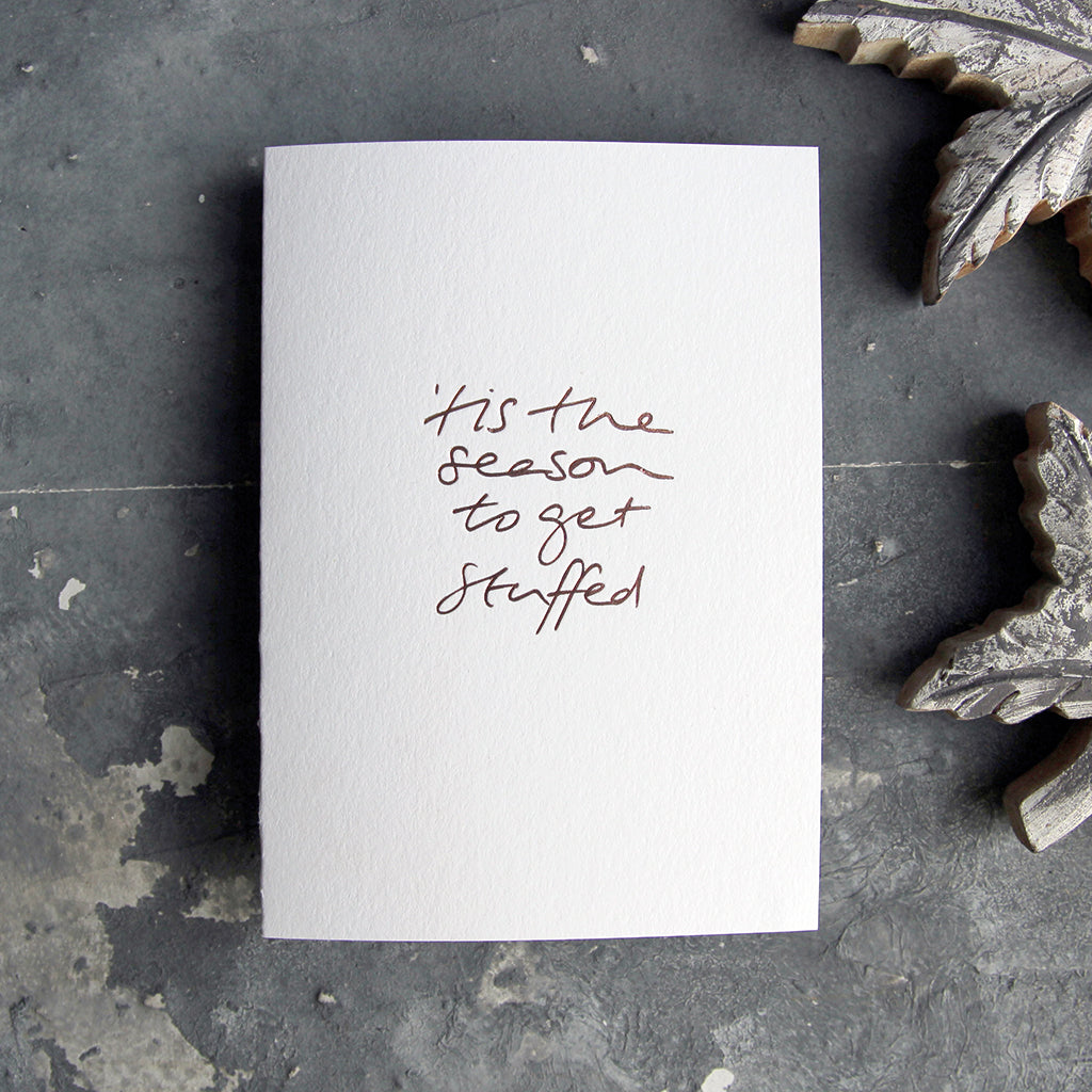 This christmas card says Tis The season to get stuffedon hand foiled on white luxury paper on grey board