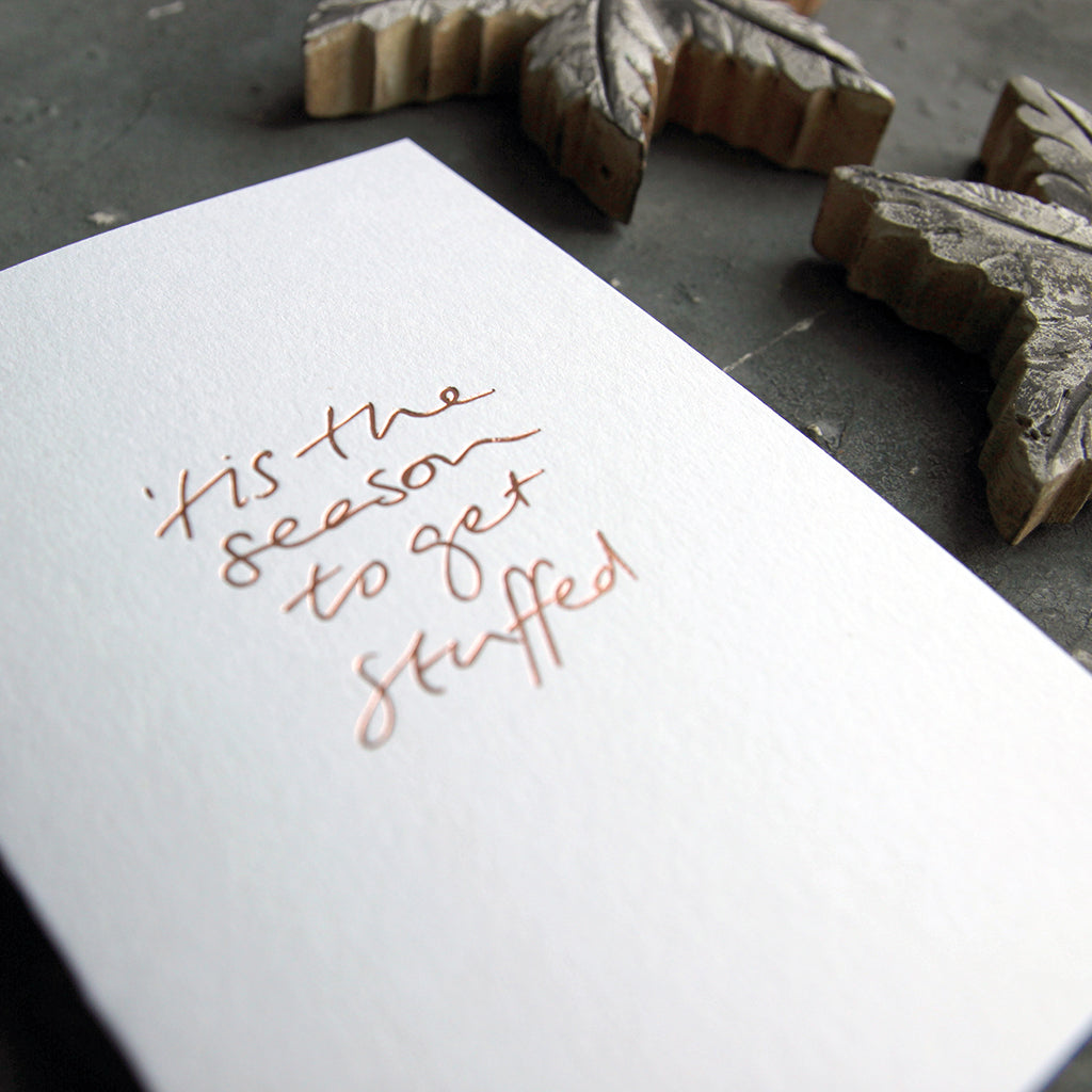 This christmas card says Tis The season to get stuffedon hand foiled on white luxury paper on grey board