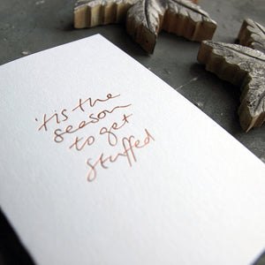 This christmas card says Tis The season to get stuffedon hand foiled on white luxury paper on grey board