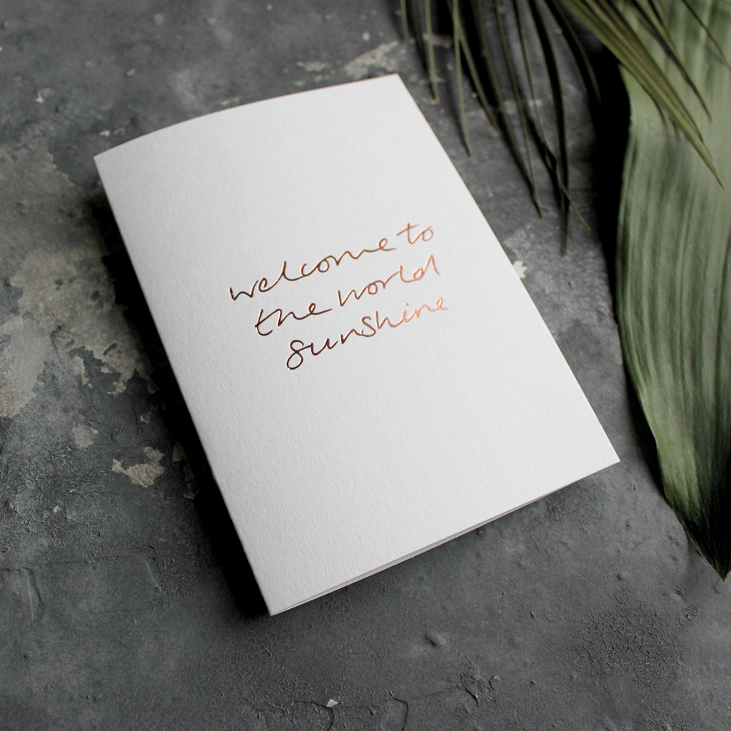 The front of the card declares Welcome To The World Sunshine hand foiled in Rose Gold