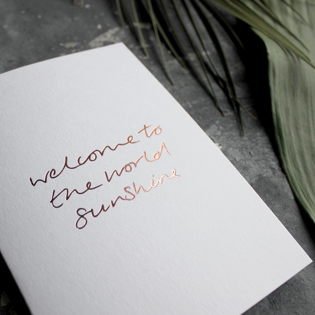 The front of the card declares Welcome To The World Sunshine hand foiled in Rose Gold