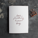 This white christmas card has 'Bah Fucking Hum Bug' handprinted in rose gold foil in handwriting on the front.