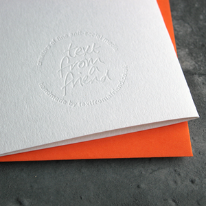the back of the card has a hand foiled transparent logo that says Text From a Friend