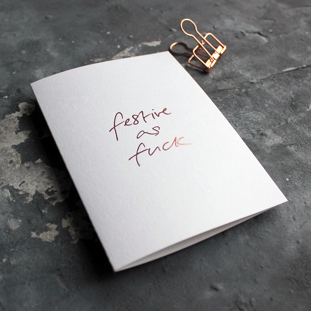 This white christmas card has 'Festive As Fuck' handprinted in rose gold foil in handwriting on the front.