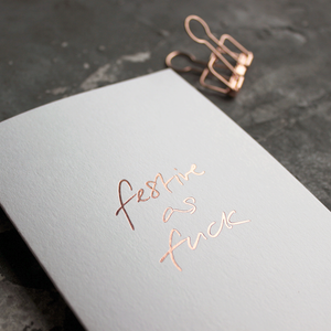 This white christmas card has 'Festive As Fuck' handprinted in rose gold foil in handwriting on the front.