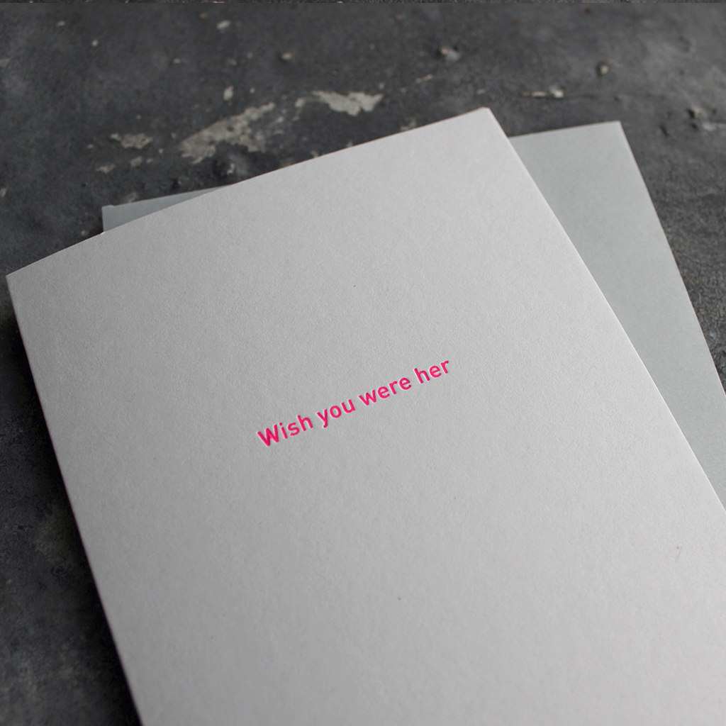 The front of the card says Wish You Were Her and is stamped in neon pink foil on a pale grey card