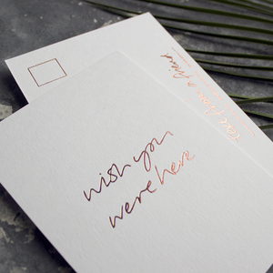 a hand pressed rose gold foil postcard that says Wish You Were Here