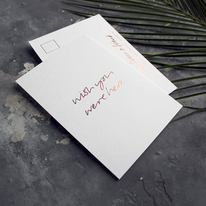 a hand pressed rose gold foil postcard that says Wish You Were Here