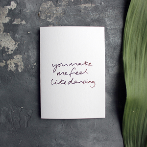 the handwritten words 'you make me feel like dancing' are hand foiled in rose gold on the front of the card