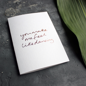 the handwritten words 'you make me feel like dancing' are hand foiled in rose gold on the front of the card