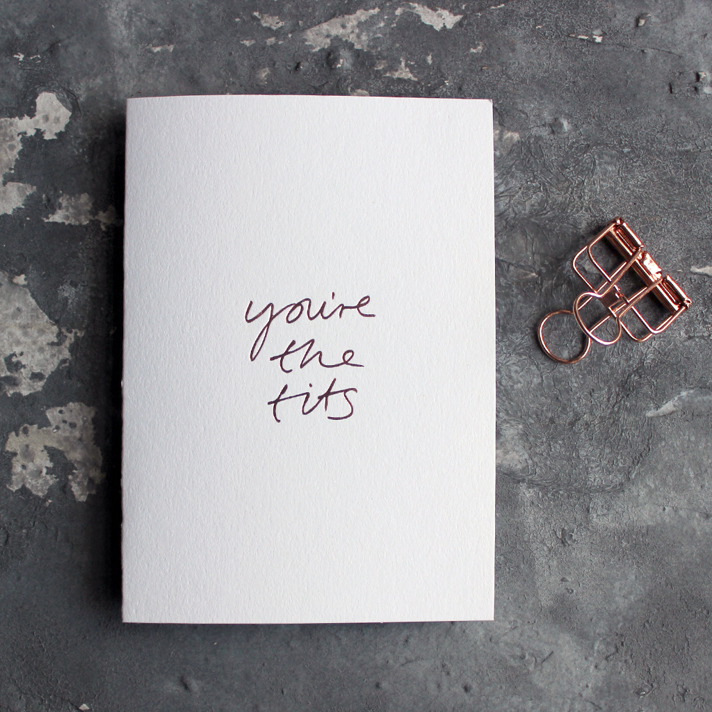The front of the white card says You're The Tits and is hand pressed in rose gold foil