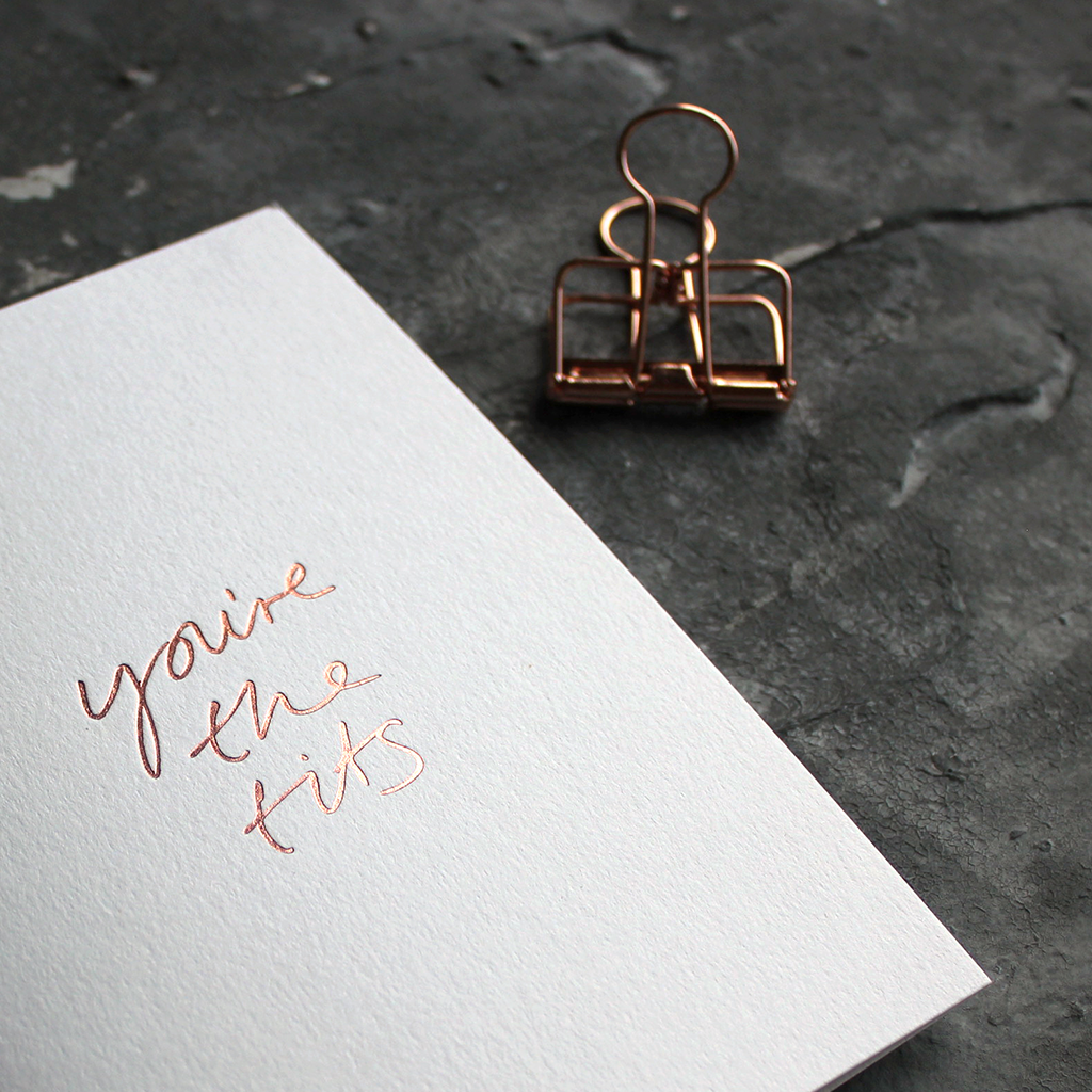 The front of the white card says You're The Tits and is hand pressed in rose gold foil