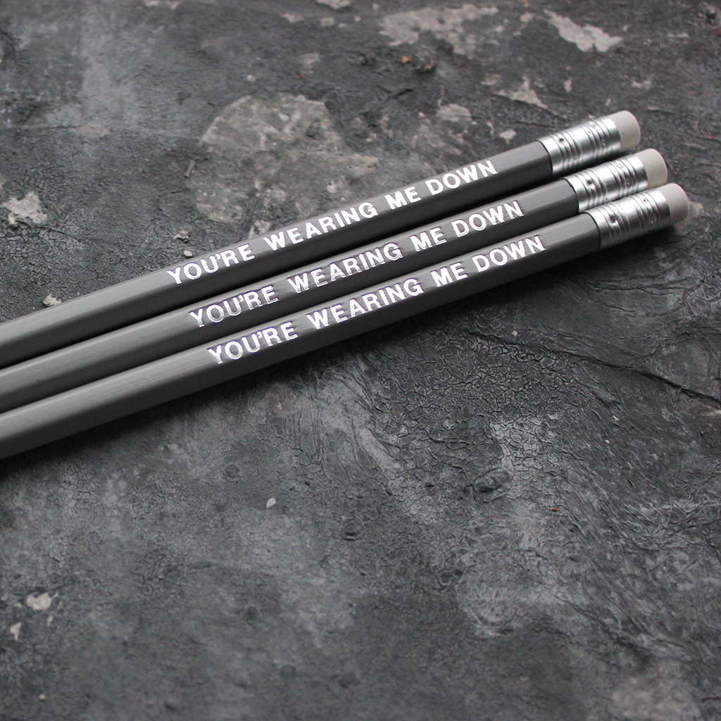 Grey pencils with a silver foil blocked message that says You're Wearing Me Down