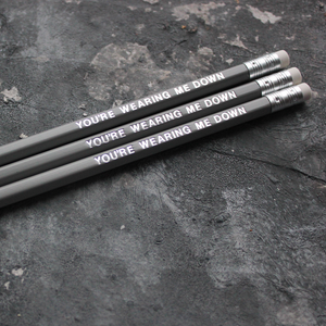 Grey pencils with a silver foil blocked message that says You're Wearing Me Down